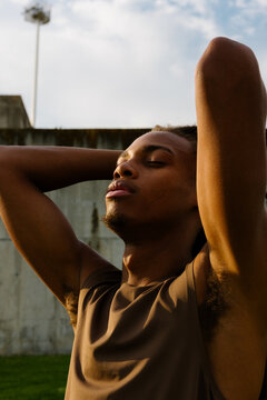 Medium shot of athletic Black man in sunshine during morning workout