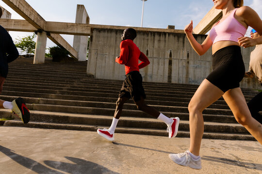 Full-body view of a diverse crew training together in a sunlit park