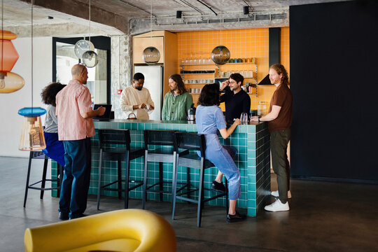 Casual Office Coworkers Chatting Around Kitchen Island