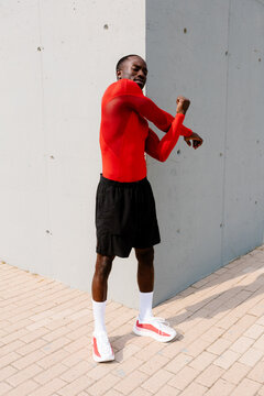 A high-performance runner, performing a body warm-up routine