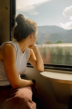 UGC Woman looking through train window at mountain landscape