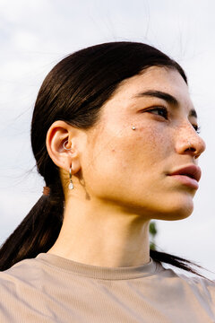 Latina athlete with serious, empowered look gazing at horizon at dawn