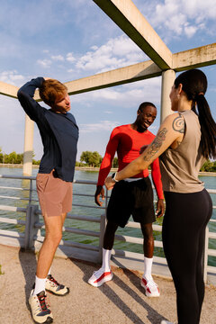 Group of athletic friends stretching during a break in their workout