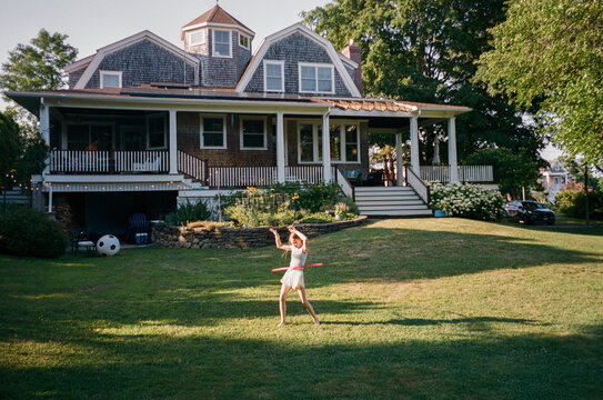 Young Girl with hula hoop in backyard summer film 