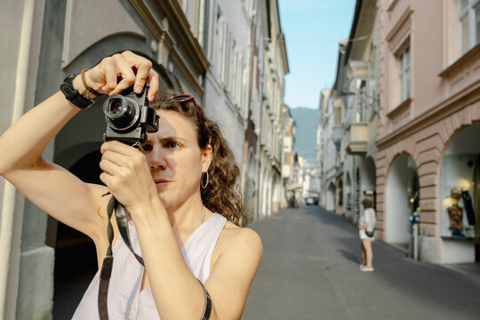 Young woman framing photo on quiet Italian old town street