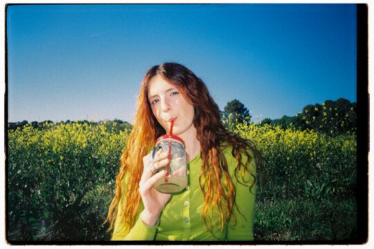 Woman Drinks juice in nature