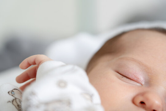 Sleeping Baby Rests on a Soft Surface in a Bright Room