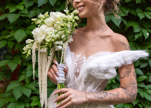 Bride holding white wedding bouquet outdoors