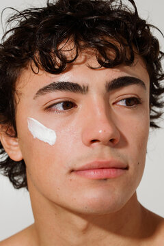 Person Applying Skin Cream to Their Face Indoors