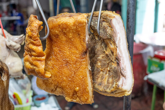 Detail of crispy pork belly known as Mu Krob in Thai, bubbly crackling on the top with tender layers of meat and a bottom layer of fat,  Chinatown, Bangkok, Thailand, Asia.