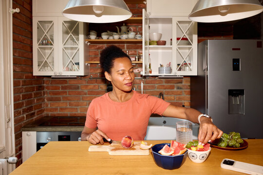 Woman prepares fruit snack at home