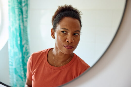 Woman checks her appearance in front of the mirror.