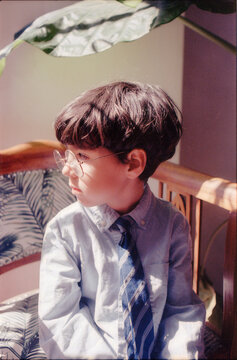 Young boy with glasses and tie looking away on 35mm film