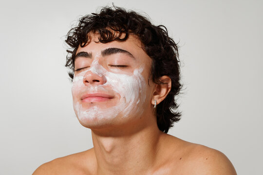 Young Man Applying Facial Cream in a Skincare Routine at Home