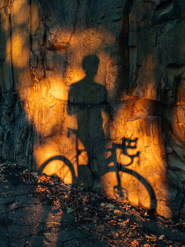 Cyclist Shadow on Sunlit Rock Wall