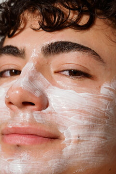 Young Man Applies Facial Mask at Home During a Skin Care Routine