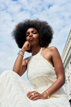 Woman Sitting Outdoors With Large Afro Hairstyle in Sunlight