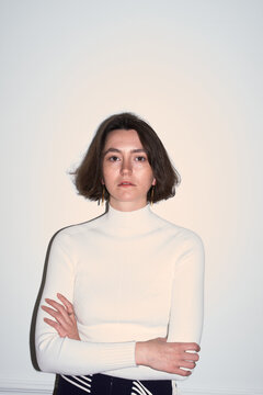 Woman Stands With Arms Crossed in Indoor Setting