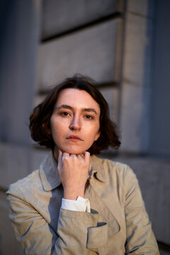 Woman Resting Her Chin on Her Hand While Sitting Outdoors