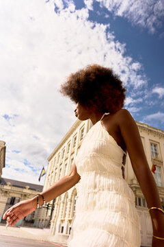 Walking Under a Blue Sky in a City With Historic Buildings