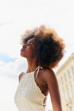 Young Woman Looks up With Clouds Behind Her During Daytime