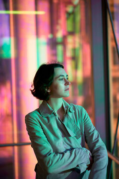 A Person Stands Near Large Windows in a Building