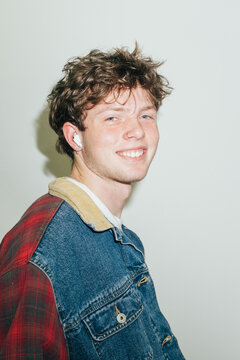 Smiling young man in denim jacket with direct flash
