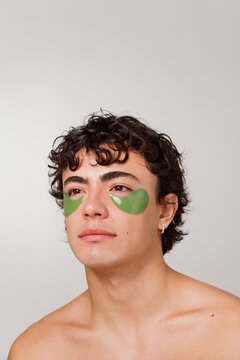 Young Man Wearing Green Eye Patches Looks up With a Calm Expression