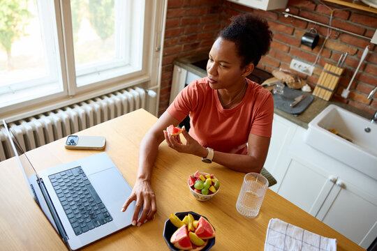 Woman working remotely, sitting in the kitchen