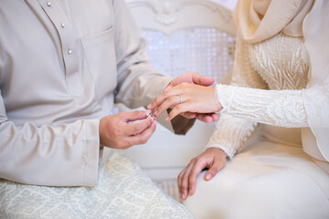 Obraz premium Malay Groom Putting Ring on Bride Hand