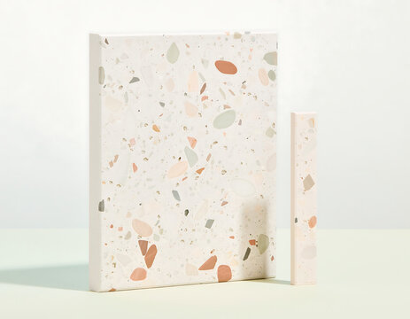 A rectangular canvas and a thin vertical strip featuring a colorful terrazzo pattern with stone chips on a light neutral background surface