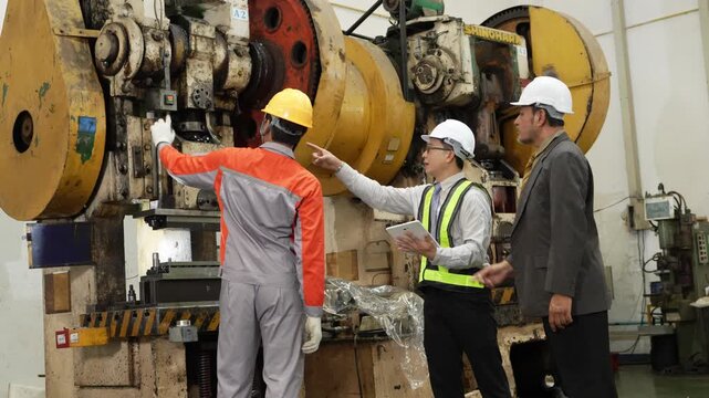 Audit team on the factory floor studies a mechanical power press while the operator explains how the tooling die changes