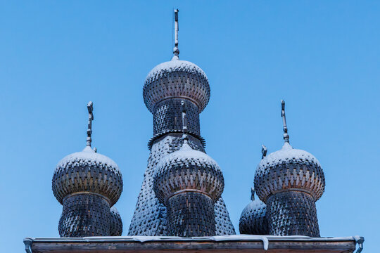 Front view of wooden lemesh cupolas and iron crosses of the historic Intercession Church in winter Zaostrovie, Arkhangelsk oblast, Russia.