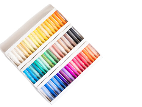 Set of soft pastel crayons in various shades in open white box, close up. Pastel crayons, set, shades, box, open, white, close up.
