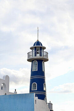 Blue Coastal Lighthouse Tower Behind Sea Resort Building