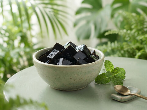 Asian black grass jelly cubes in a ceramic bowl with mint