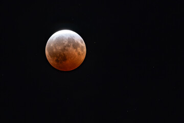 Partial blood moon lunar eclipse isolated on black in the night sky with copy space  © clsdesign