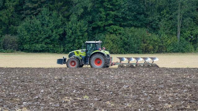 KOCĒNI, LATVIA - AUGUST 28, 2026: CLAAS tractor pulling a multi-furrow plow while plowing an agricultural field near Kocēni.
