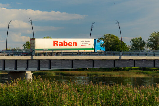 SALACGRIVA, LATVIA - AUGUST 28, 2026: Raben logistics semi-trailer truck crossing a bridge in Salacgriva, illustrating commercial road freight transport and logistics in Europe.