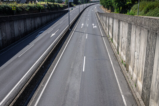 Empty urban road with guiding arrows on asphalt during the day