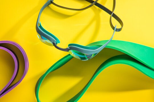 Set of sports swim  accessories, fitness bands on yellow background top view.