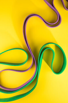 Set of sports swim  accessories, fitness bands on yellow background top view.