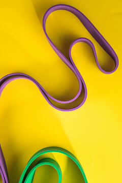 Set of sports swim  accessories, fitness bands on yellow background top view.