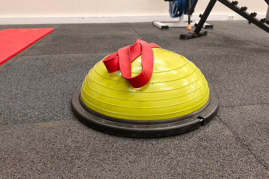 bosu ball with resistance band on gym floor. balance trainer ready for workout training and core exercise. modern fitness equipment for balance training and strength conditioning in professional gym