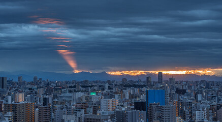 Fototapeta premium Wide Tokyo City Panorama Beneath Dark Clouds at Sunset