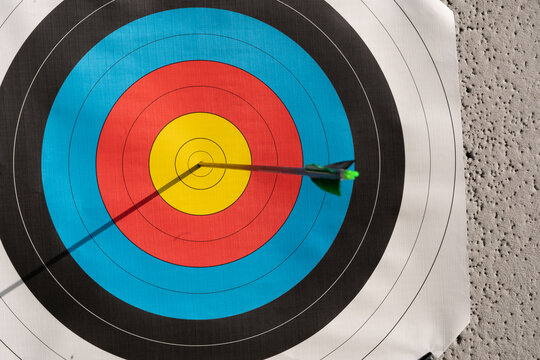 Arrow hitting the center of a colorful archery target, symbolizing success and achievement
