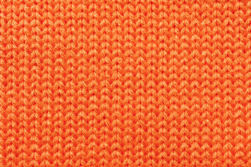 Bright orange knitted fabric texture with soft wool stitches © Iryna Miadzvedzeva