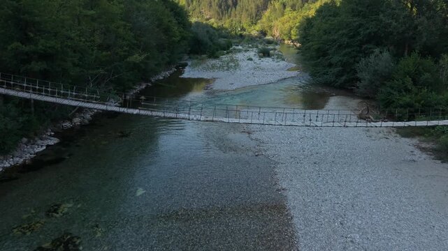 Aerial Flyover Over Wooden Suspension Footbridge Across Low Level Neretva River in Glavaticevo Bosnia