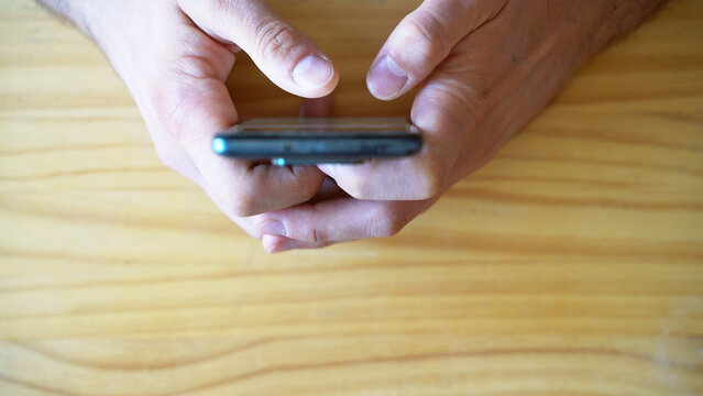 Phone addiction. Infinite scrolling. Doomscrolling. Texting. Top view shot of Hands using smartphone
