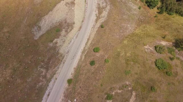 Aerial Top Down View of Mountain Road Passing Through Sunburnt Dry Landscape on Visocica Mountain Bosnia